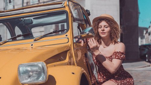Modèle se remaquille dans le rétrovisueur d'une 2CV