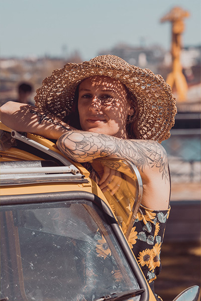 Femme avec une robe a motif fleuri jaune, 2cv jaune et grue jaune avec la loire et le ciel bleu - couleurs complémentaires