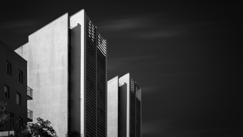 Photo en noir et blanc de bâtiments modernes à Nantes, avec une architecture angulaire et des façades claires et sombres. 