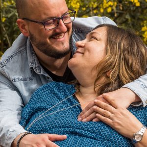 Couple échangeant un regard complice dans un parc.