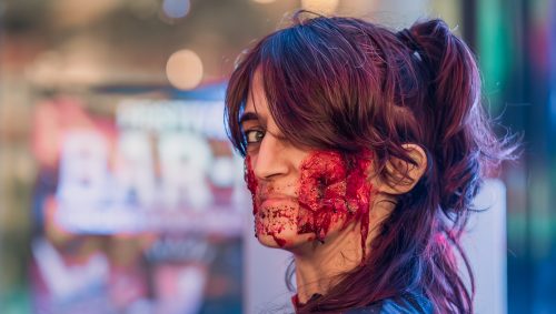 Serveuse d'Halloween avec un maquillage sanglant autour de la bouche et les yeux ouverts.