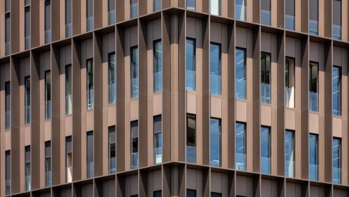 Façade angulaire de la maison de l'innovation avec les fenêtres entourées de brise-soleil en aluminium.