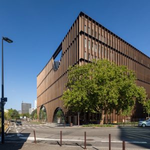 Les facades arrière illuminées de la maisonde l'innovation, montrant des variations de couleurs du cuivre au brun.