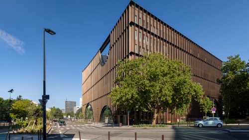 Les facades arrière illuminées de la maisonde l'innovation, montrant des variations de couleurs du cuivre au brun.
